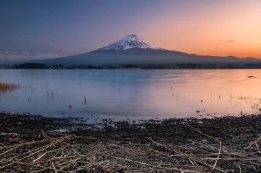 Mavi gökyüzü günbatımı, göl ile taş ön planda Kawaguchiko Gölü, MT Fuji Japonya günbatımında