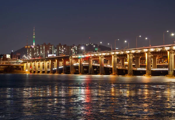 SEOUL, CORÉE DU SUD - 22 JAN 2018 : Pont Banpo et tour N Séoul la nuit avec réflexion sur la rivière gelée — Photo