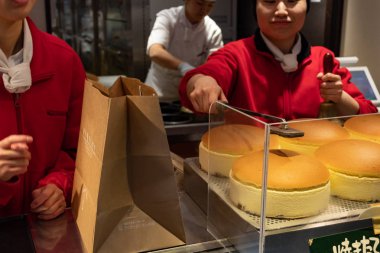 Osaka, Japonya - 29 Ocak 2018: ünlü Japon sünger kek Rikuro Ojisan deposunda ateşle işaretleme kadın