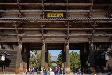 NARA, JAPAN - JAN 30, 2018: Tourists walking in entrance of Todaiji Nandaimon giant temple door in Nara clipart