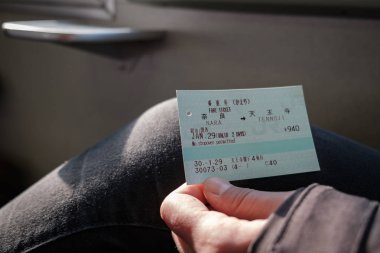 Nara, Japonya - 30 Ocak 2018: Jr raylar tutan kişi tren için Tennoji Nara üzerinden bileti