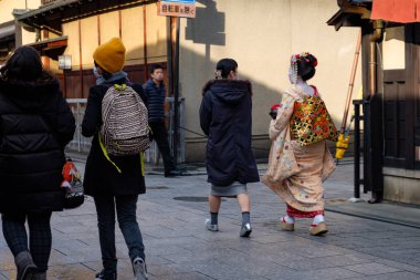Kyoto, Japonya - 08 Şubat 2018: güzel genç Japon Maiko beyaz makyaj ve geleneksel kimono arkadan Kyoto sokaklarında yürüyüş