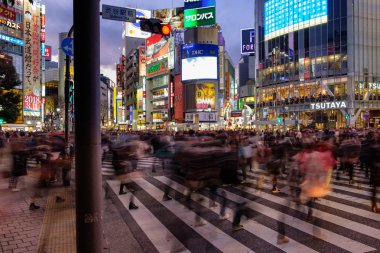 Tokyo, Japonya - 12 Şubat 2018: Shibuya geçerken binaların ve arkasında parlak renkli panoları ile insanlar