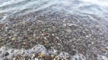 Orta Ren 'in sakin şeffaf nehir dalgaları ıslak çakıl taşlarıyla kaplı kıyıya vuruyor. Kristal sahil suyunun görüntülerini kapatın. Uzayı kopyalayın, doğal su arka plan görüntülerini alın.