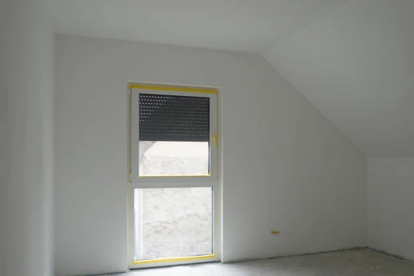 白色空房间 有阁楼天花板 法国窗 灰色混凝土地板 滚子百叶窗是第三层 带倾斜屋顶的阁楼卧室的设计 全景窗 日耳曼 复制空间 — 图库照片