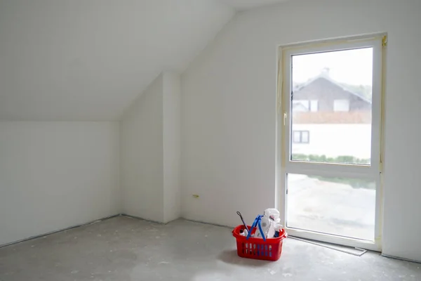准备粉刷的房间 有顶楼 法国窗口 灰色的混凝土地板 红色塑料篮子 有表面清洁剂 房屋的概念 房屋的维修 复制空间 — 图库照片