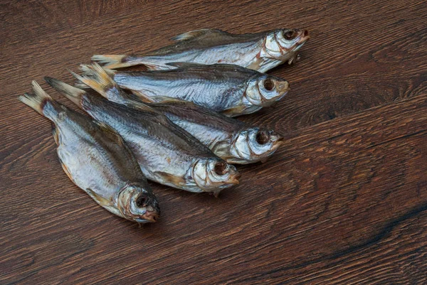 Pescado seco sobre un fondo de madera oscura — Foto de Stock