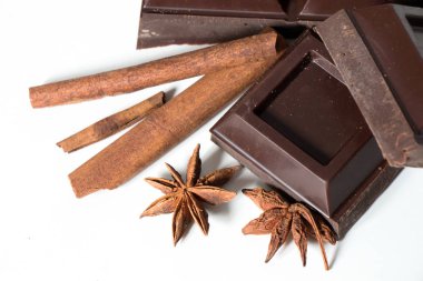 Çikolata ve tarçın parçaları beyaz arkaplanda izole edilmiş.