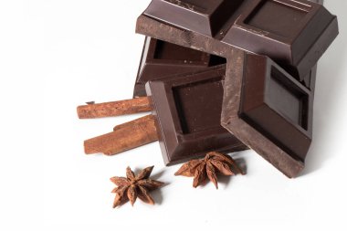 Çikolata ve tarçın parçaları beyaz arkaplanda izole edilmiş.