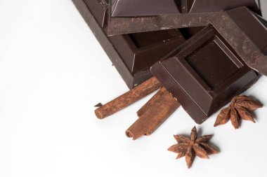 Çikolata ve tarçın parçaları beyaz arkaplanda izole edilmiş.