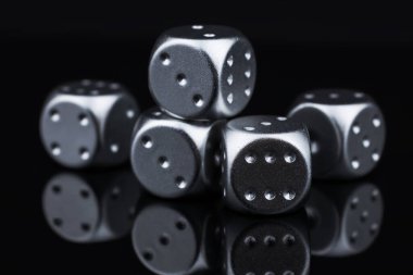 Yukarıdan siyah arkaplanda beş gümüş zar görünümü.