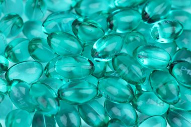 Arka plan olarak mavi vitamin kapsülleri, üst görünüm.