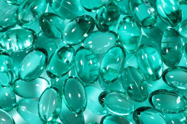 Kabukta sıvı vitaminli mavi kapsüller. Eklem dişleri ve kemikler için beslenme takviyesi içeren mavi kapsüller..