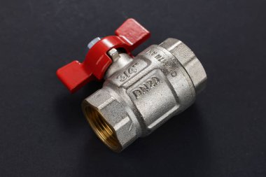 Kırmızı saplı top valfi koyu arkaplanda izole edildi.