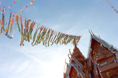 Bu resimde, Tay halkının bir gelenektir. Bu Budist hak iş var. Banknotlar birlikte dikilir. Bayrak birlikte karıştırılır. Güzel üst üste sıralanmış. Kilisenin çatısı bağla