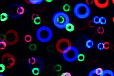 Bu arka plan var şeklinde çörek bokeh bulanıklık. Beyaz ve kırmızı, pembe, yeşil, mavi boyunca dağınık.