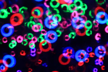 Bu arka plan var şeklinde çörek bokeh bulanıklık. Beyaz ve kırmızı, pembe, yeşil, mavi boyunca dağınık.