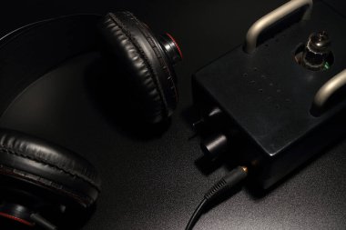 Tam boy kulaklıklar siyah arka planda bir tüp önamfisi ile yerleştiriliyor..