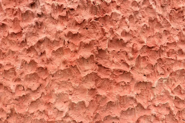Beton duvarın yüzeyi onu sert yapar. Kırmızımsı pembe renkli alışılmadık bir doku..