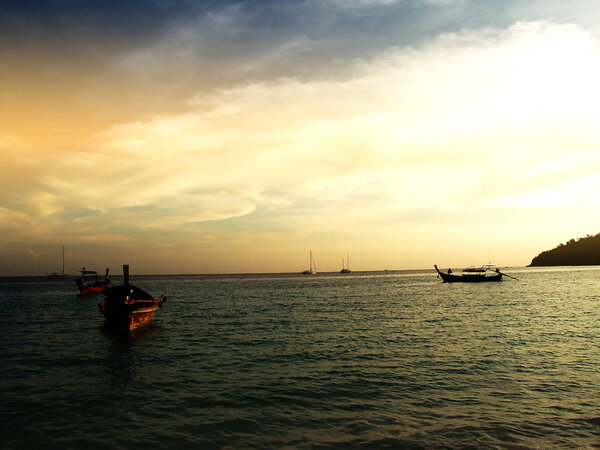 Сумерки солнца и лодки в море
