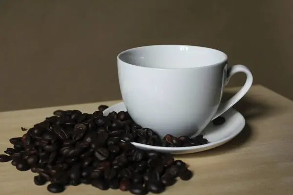 Coffee beans, white coffee mugs placed on wooden