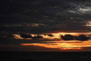 Gün batımının turuncu ışığı denize düşüyor.