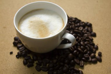 Süt köpük kahve kupaları ve kahve çekirdekleri