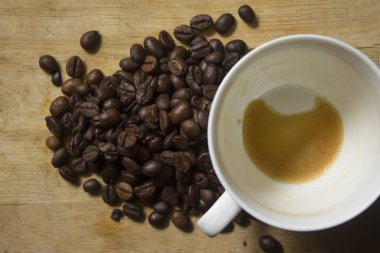 Beyaz kahve kupaları ve kahve çekirdekleri ahşap zemin üzerinde kahve lekeleri.