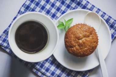 Kumaş üzerine beyaz cam ve muz pasta siyah kahve.