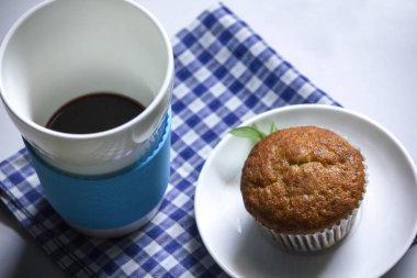 Kumaş üzerine beyaz cam ve muz pasta siyah kahve.