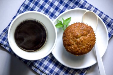 Kumaş üzerine beyaz cam ve muz pasta siyah kahve.