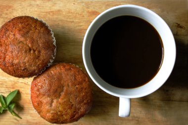 Beyaz cam ve muz kek koymak bir ahşap üzerine siyah kahve