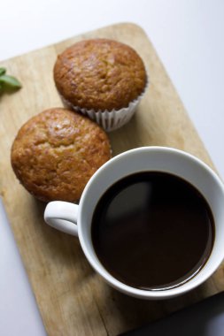 Beyaz cam ve muz kek koymak bir ahşap üzerine siyah kahve