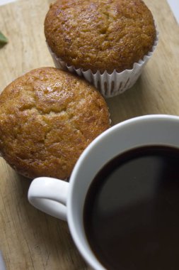 Beyaz cam ve muz kek koymak bir ahşap üzerine siyah kahve