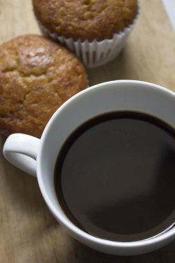 Beyaz cam ve muz kek koymak bir ahşap üzerine siyah kahve