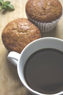 Beyaz cam ve muz kek koymak bir ahşap üzerine siyah kahve