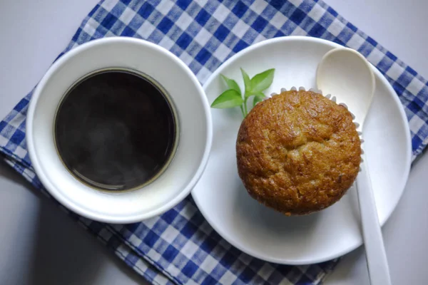 Kumaş üzerine beyaz cam ve muz pasta siyah kahve.