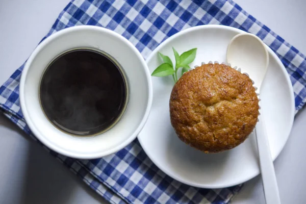 Kumaş üzerine beyaz cam ve muz pasta siyah kahve.