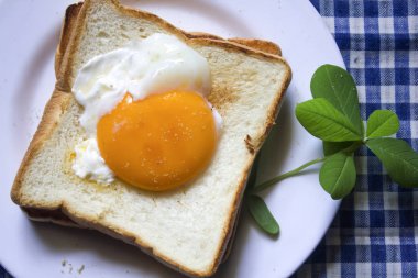 Beyaz bir tabak içinde yumurtalar ekmeğin.