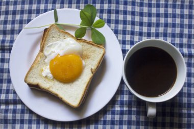 Sahanda yumurta ekmek ve bir bardak siyah kahve.