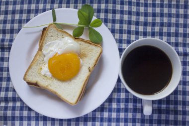 Sahanda yumurta ekmek ve bir bardak siyah kahve.