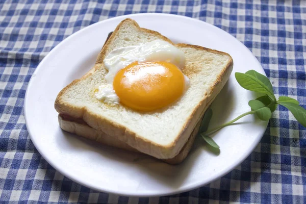 Beyaz bir tabak içinde yumurtalar ekmeğin.