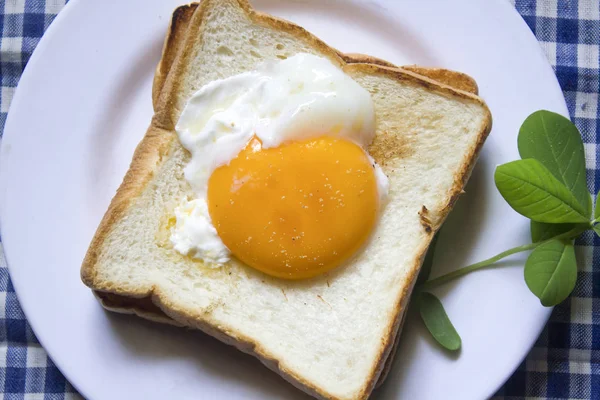 Beyaz bir tabak içinde yumurtalar ekmeğin.