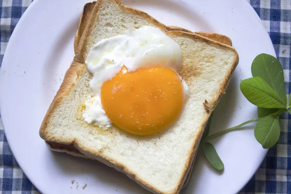 Beyaz bir tabak içinde yumurtalar ekmeğin.
