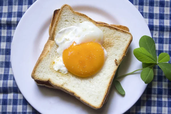 Beyaz bir tabak içinde yumurtalar ekmeğin.