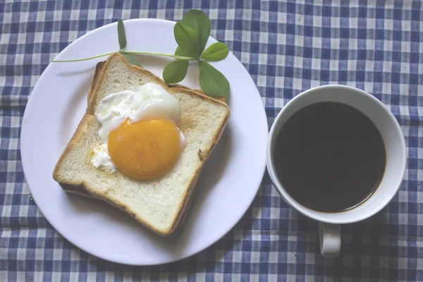 Sahanda yumurta ekmek ve bir bardak siyah kahve.