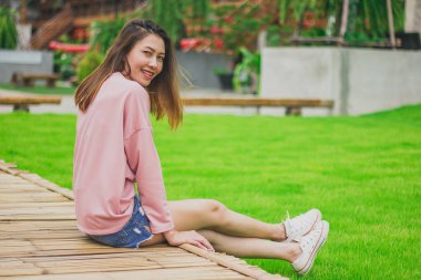 Bambu köprüde oturan kadın