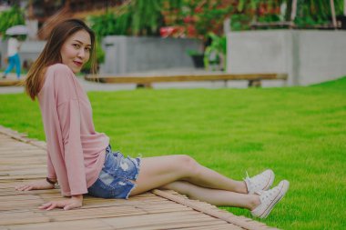 Bambu köprüde oturan kadın