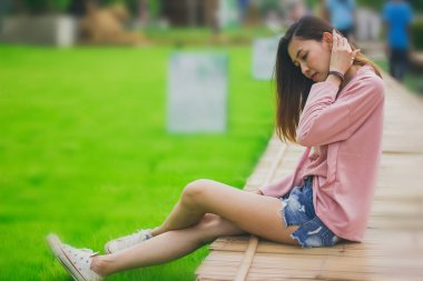 Bambu köprüde oturan kadın