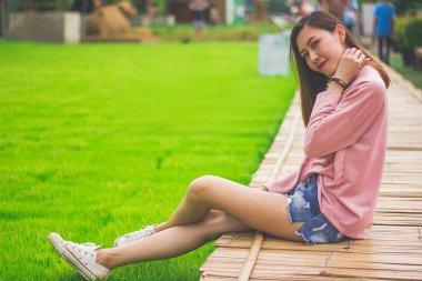 Bambu köprüde oturan kadın